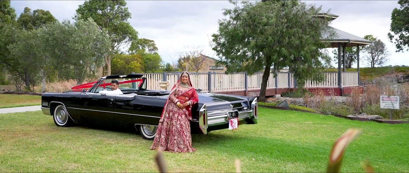 A guest beside the vintage convertible parked on the lawn
